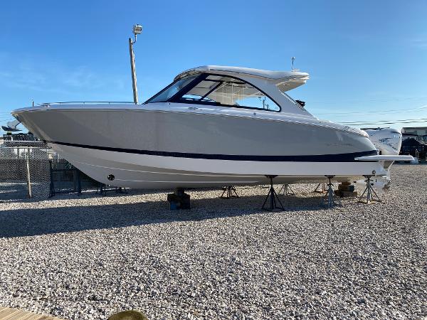 Regal LX36 2025 Regal LX36 boat on display in a gravel lot.