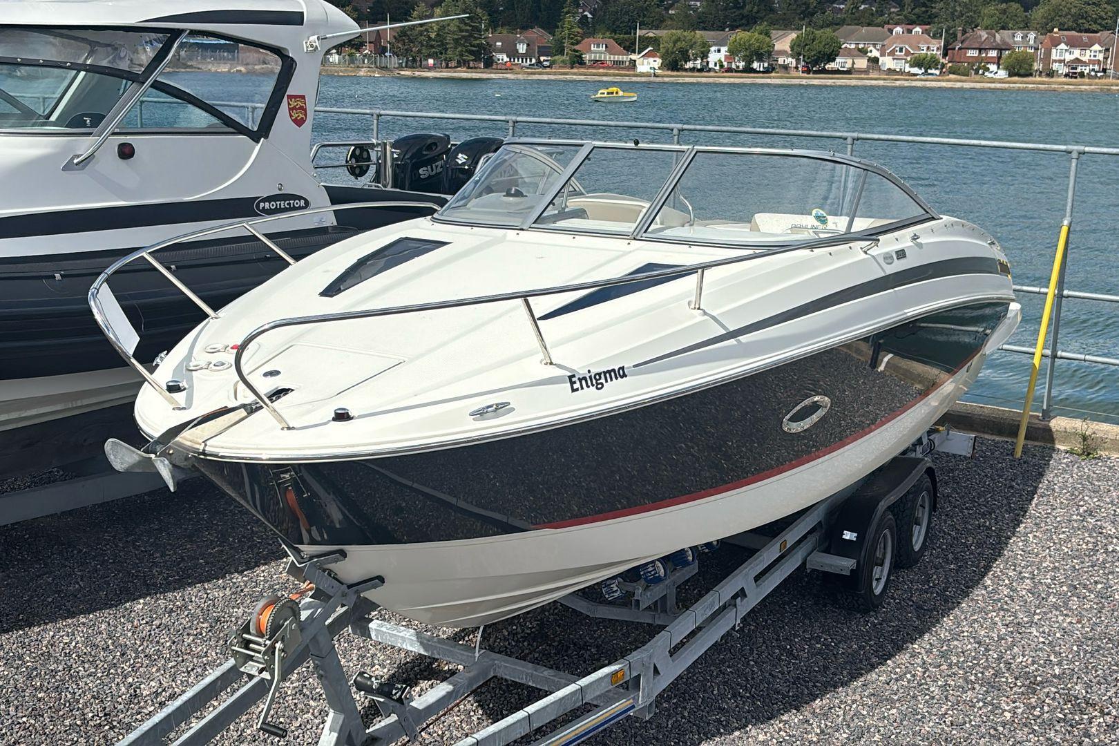 Bayliner 742 Cuddy 2015 Bayliner 742 Cuddy boat on trailer by waterfront, sunny day.