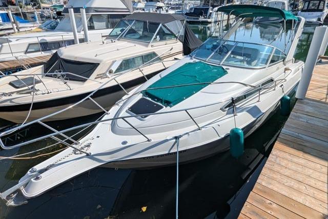 Regal 272 Commodore 1995 Regal 272 Commodore boat docked at marina, featuring sleek design and green canopy.