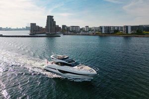 Princess S66 Luxury Princess S66 yacht cruising near modern waterfront buildings, 2021 model.