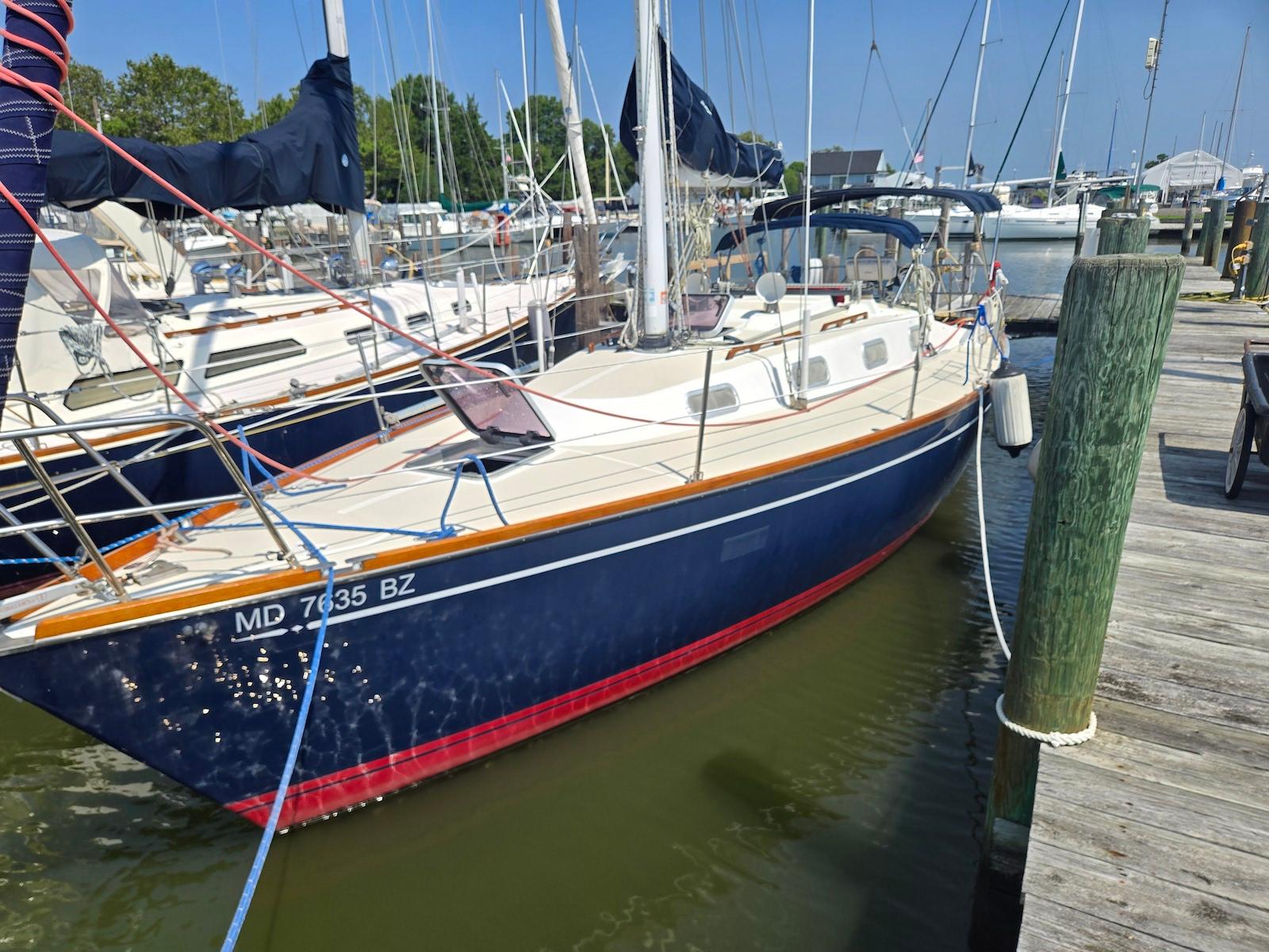 Tartan 31 Sailboat docked at marina, 1994 Tartan 31 model, blue hull, sunny day.