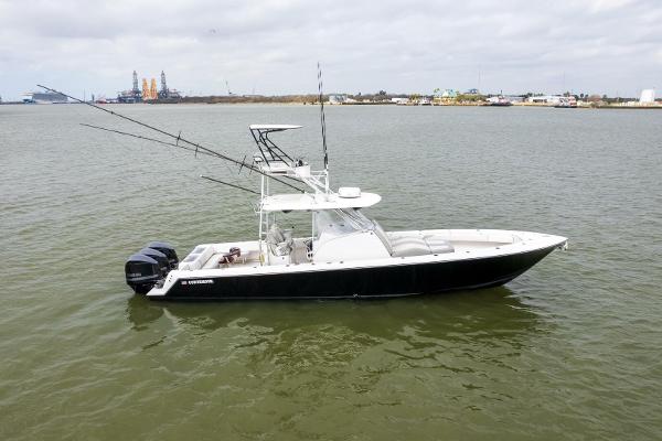 Contender 39 Fish Around 2017 Contender 39 Fish Around boat on calm water, equipped with fishing rods.