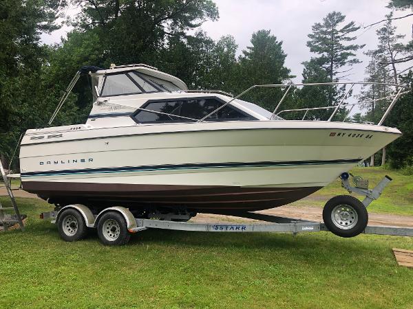 Bayliner Ciera 2452 Express 1997 Bayliner Ciera 2452 Express on trailer, parked on grass with trees in background.