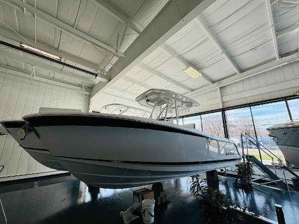Blackfin 252 CC 2024 Blackfin 252 CC boat displayed in a showroom with sleek design.