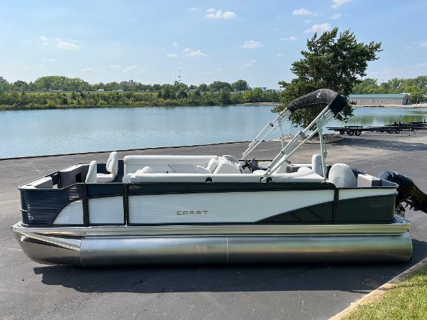 Crest Classic Fish 220 2024 Crest Classic Fish 220 pontoon boat parked by a serene lake.