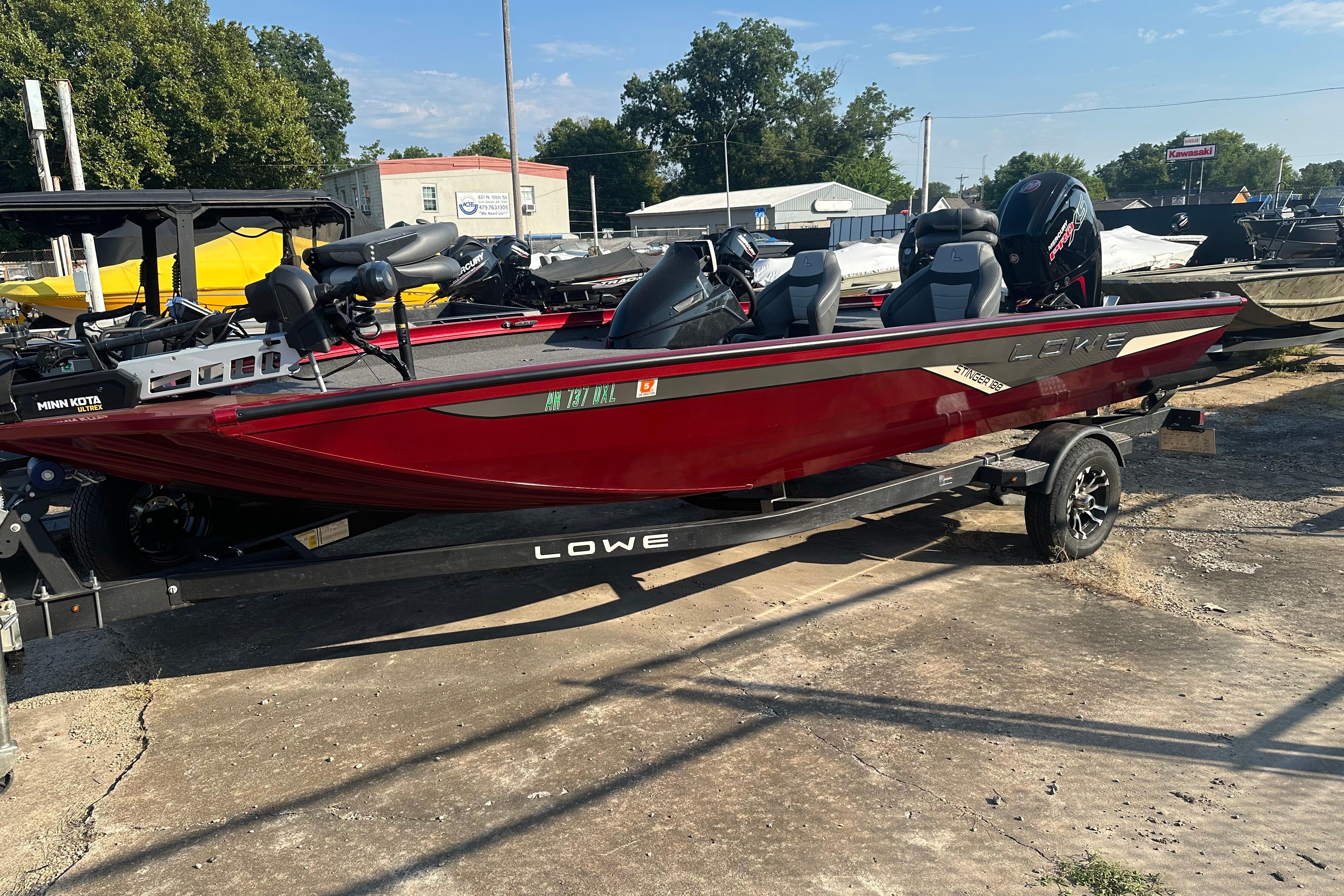 Lowe Stinger 188 2022 Lowe Stinger 188 boat in vibrant red on a trailer, parked outdoors.