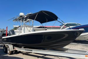 Contender 25 Bay 2015 Contender 25 Bay boat on trailer, black hull, under clear blue sky.