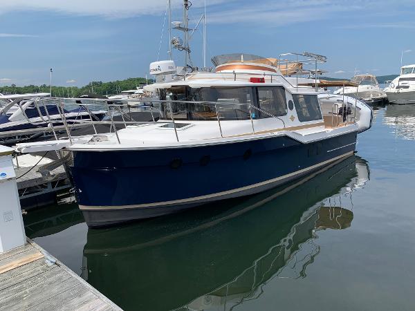 Ranger Tugs R-29 CB 2019 Ranger Tugs R-29 CB boat docked in a marina, featuring a sleek blue hull.