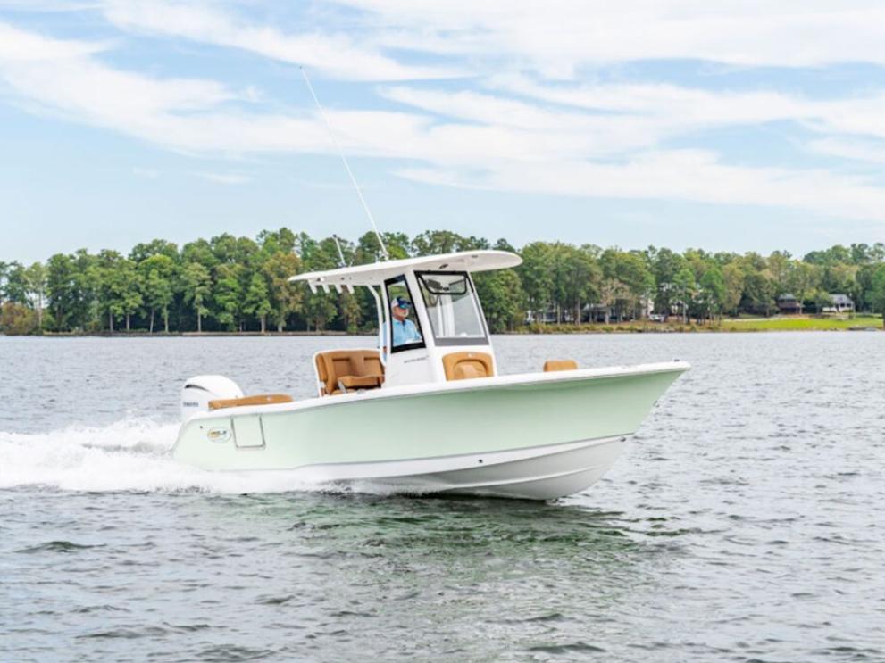 Sea Hunt Ultra 235 SE 2026 Sea Hunt Ultra 235 SE boat cruising on a lake with forested shoreline.
