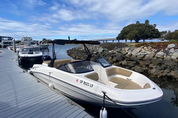 Bayliner VR6 Bowrider OB 2022 Bayliner VR6 Bowrider OB docked by rocky shoreline under blue sky.