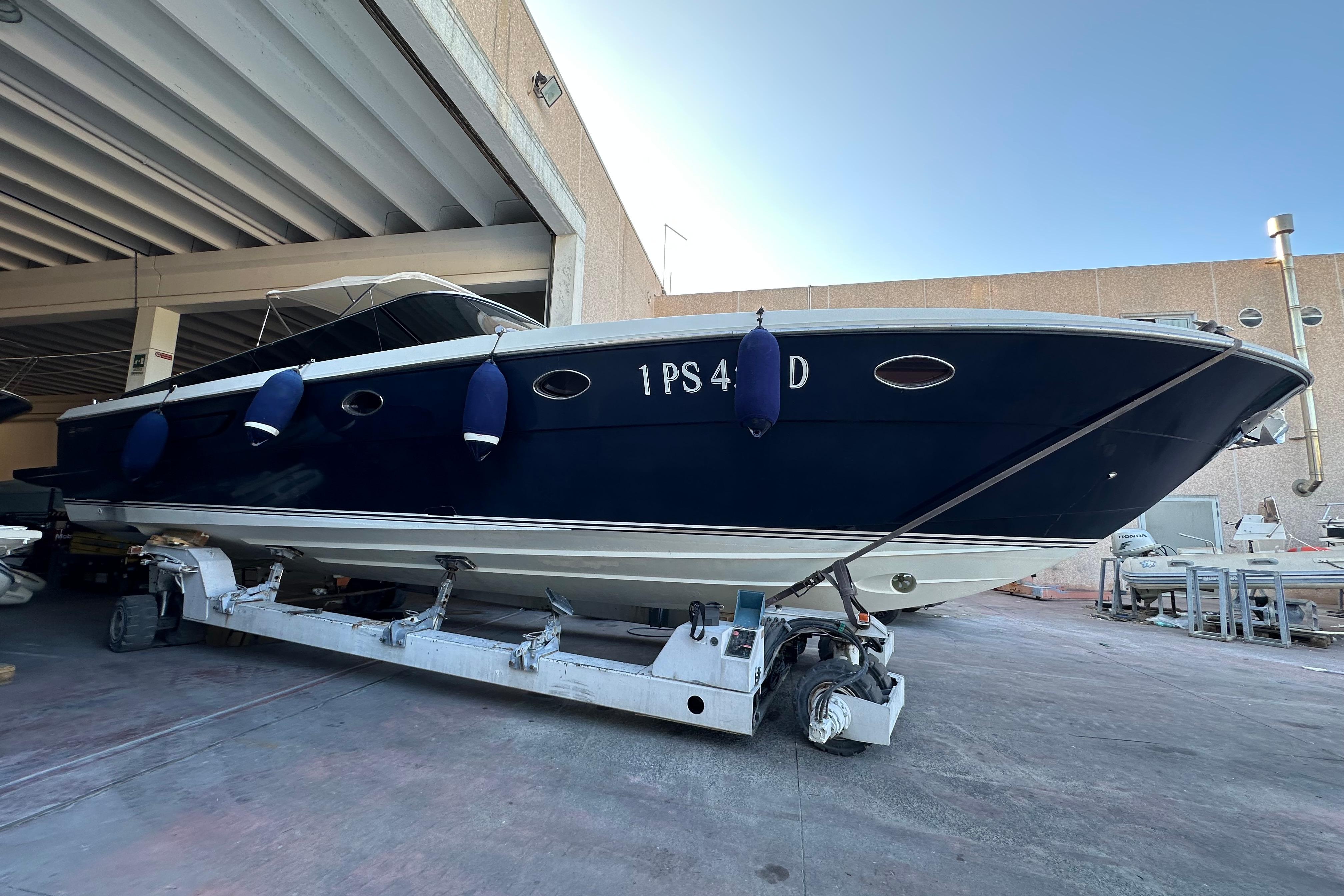 Itama Forty 2006 Itama Forty yacht in dry dock, blue hull, white trim, under a covered area.