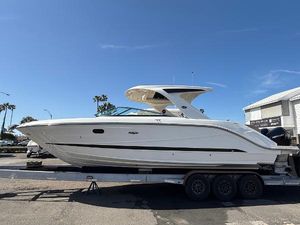 Sea Ray SLX 310 Outboard 2025 Sea Ray SLX 310 OB boat on trailer, sunny day, palm trees in background.