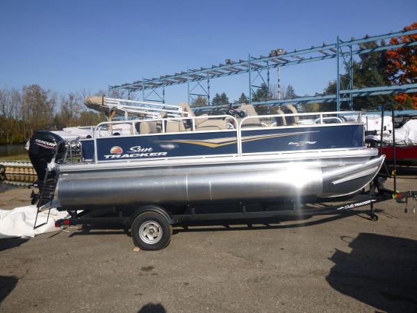 Sun Tracker Bass Buggy 18 DLX 2025 Sun Tracker Bass Buggy 18 DLX pontoon boat on trailer, parked outdoors.