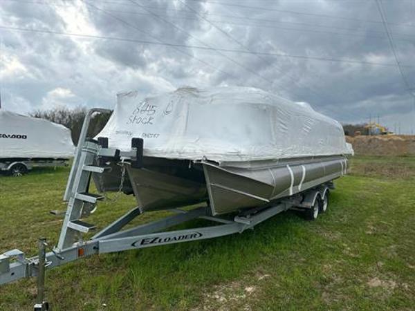 Manitou 24 Explore 2024 Manitou 24 Explore pontoon boat on E-Z Loader trailer, covered in protective wrap.