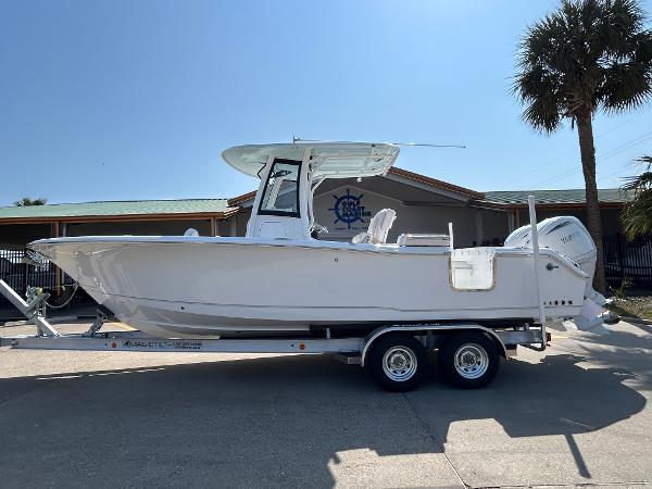 Sea Hunt Gamefish 25 2025 Sea Hunt Gamefish 25 boat on trailer, parked outdoors near a building and palm tree.