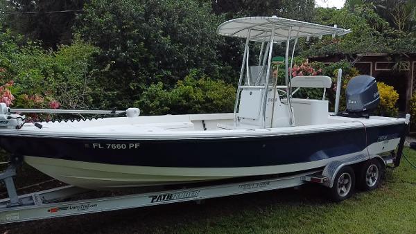 Pathfinder 2400 TRS 2012 Pathfinder 2400 TRS boat on trailer, parked on grass, surrounded by greenery.