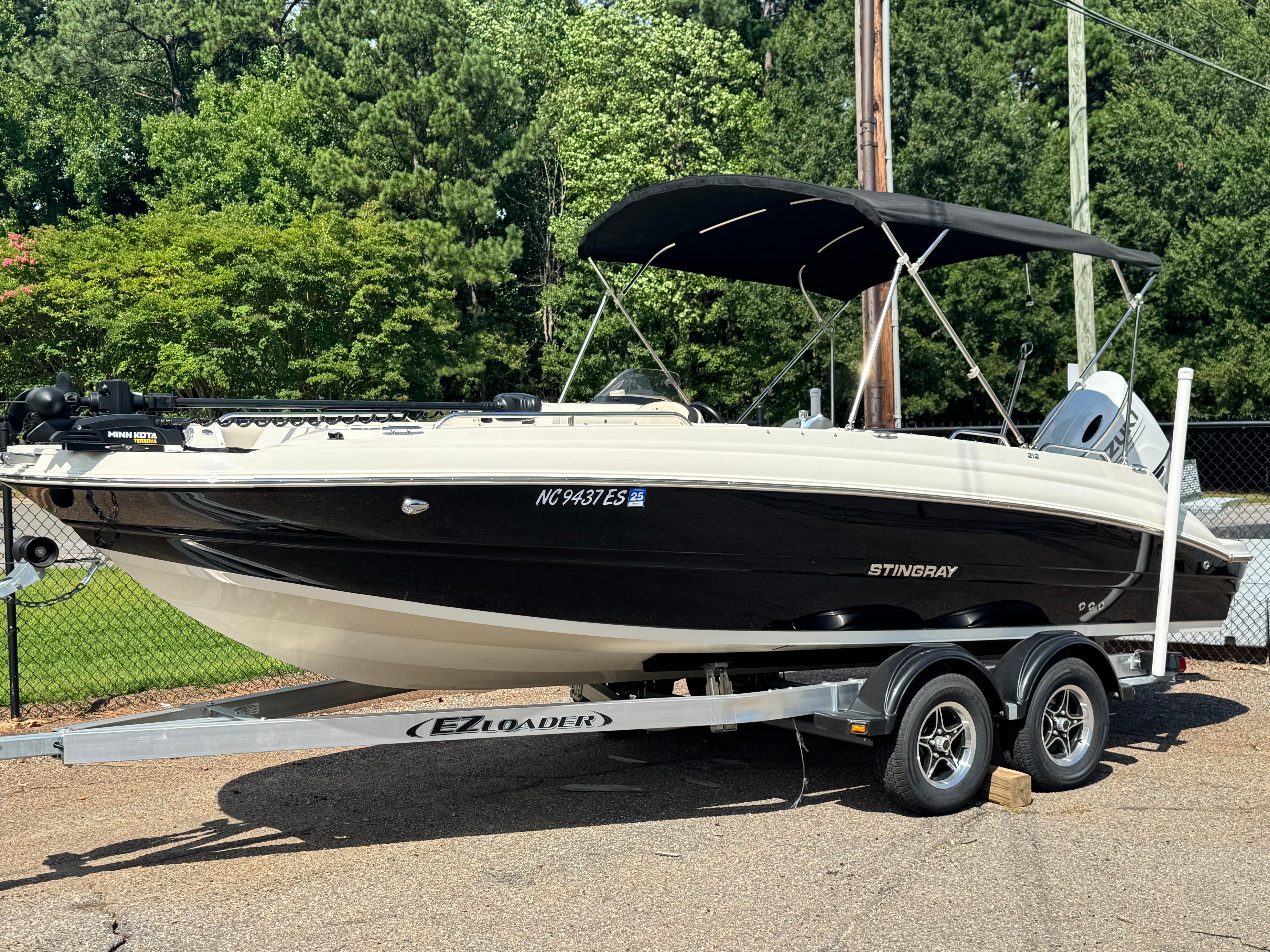 Stingray 212 SC 2021 Stingray 212 SC boat on trailer, black and white, parked outdoors.