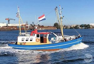 Kotter 15 Vintage 1960 Kotter 15 boat with Dutch flag sailing in a harbor.