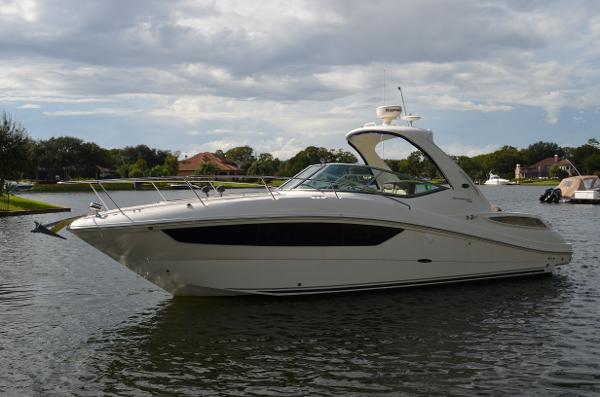 Sea Ray 330 Sundancer 2015 Sea Ray 330 Sundancer yacht on a calm lake under cloudy skies.
