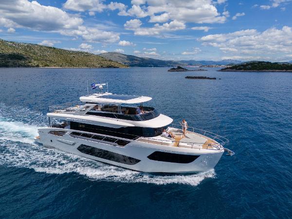 Absolute 75 Navetta Co Ownership 2024 Absolute NAVETTA 75 yacht cruising on a clear blue sea under a partly cloudy sky.