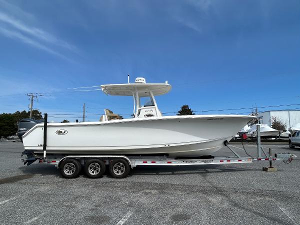 Sea Hunt Gamefish 30 Coffin Box 2015 Sea Hunt Gamefish 30 boat on trailer, side view, under clear blue sky.