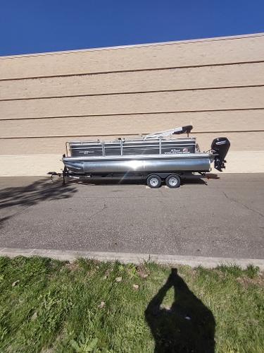 Sun Tracker Party Barge 22 RF DLX 2025 Sun Tracker Party Barge 22 RF DLX pontoon boat parked on trailer.