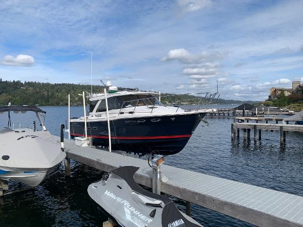 Cutwater C-302 Coupe 2018 Cutwater C-302 Coupe docked on a scenic lake with jet ski nearby.