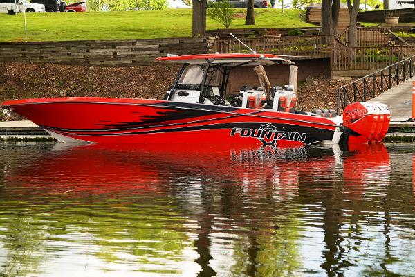 Fountain 38 SC 2022 Fountain 38 SC boat in vibrant red, docked on calm water.