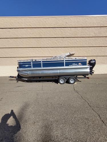 Sun Tracker Fishin' Barge 20 DLX 2025 Sun Tracker Fishin' Barge 20 DLX pontoon boat on trailer, parked outdoors.