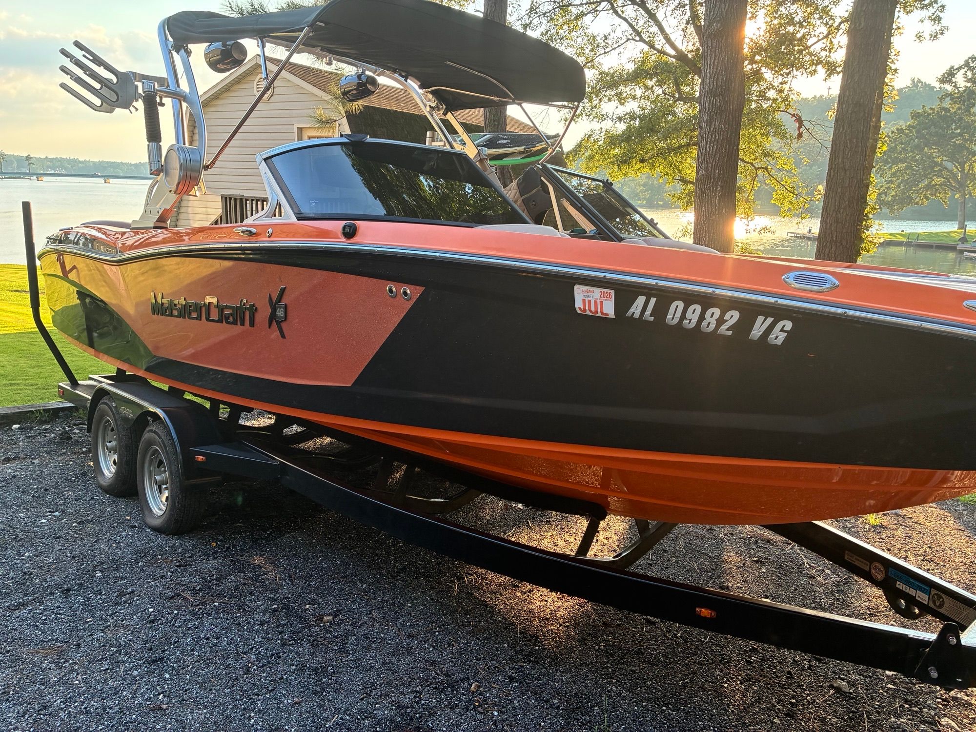 MasterCraft X46 2016 MasterCraft X46 boat on trailer by lakeside at sunset.