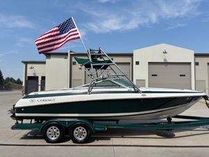 Cobalt 220 1995 Cobalt 220 boat on trailer with American flag, parked outside industrial building.