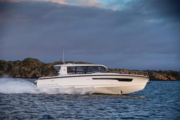 Nimbus C11 2024 Nimbus C11 boat cruising on the water near rocky coastline.