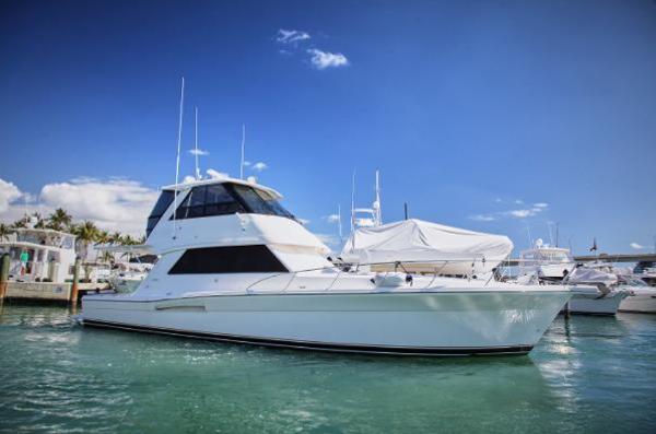 Riviera 48 2003 Riviera 48 yacht docked in a marina under a clear blue sky.