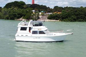 Gulfstar 44 Motor Yacht 1986 Gulfstar 44 Motor Yacht cruising near a scenic lighthouse and lush greenery.