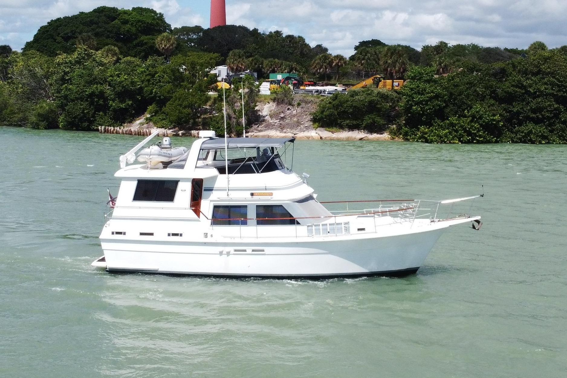 Gulfstar 44 Motor Yacht 1986 Gulfstar 44 Motor Yacht cruising near a scenic lighthouse and lush greenery.