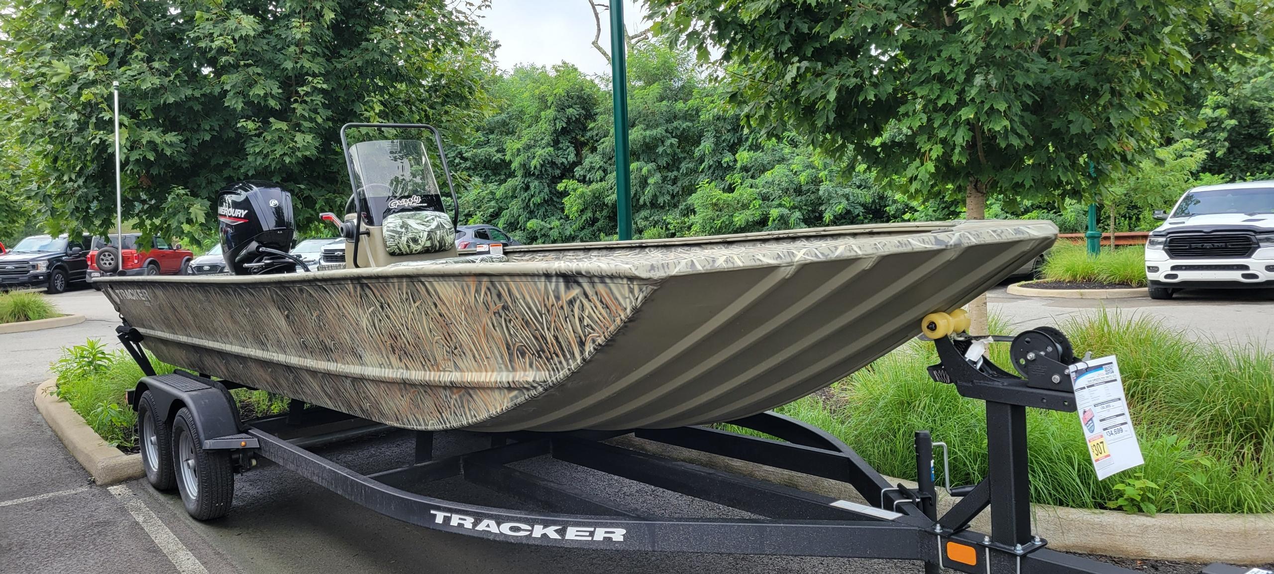 Tracker Grizzly 2072 CC 2025 Tracker Grizzly 2072 CC boat on trailer, parked outdoors with trees in background.