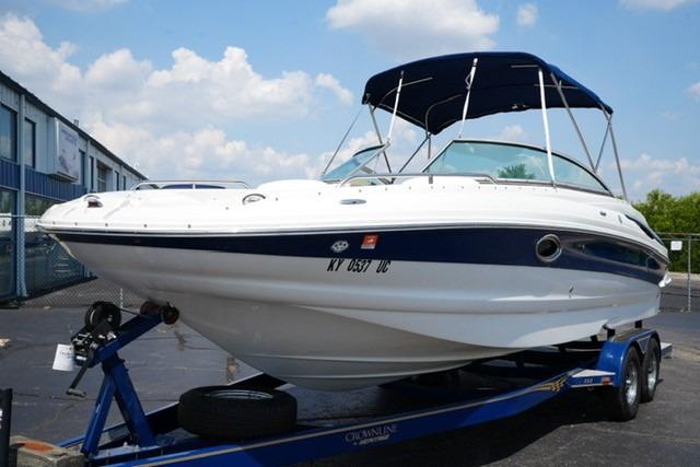 Crownline 252 EX 2006 Crownline 252 EX boat on trailer with blue canopy, parked outdoors.