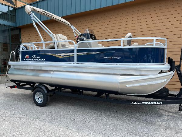 Sun Tracker Bass Buggy 18 DLX 2025 Sun Tracker Bass Buggy 18 DLX pontoon boat on trailer, side view.