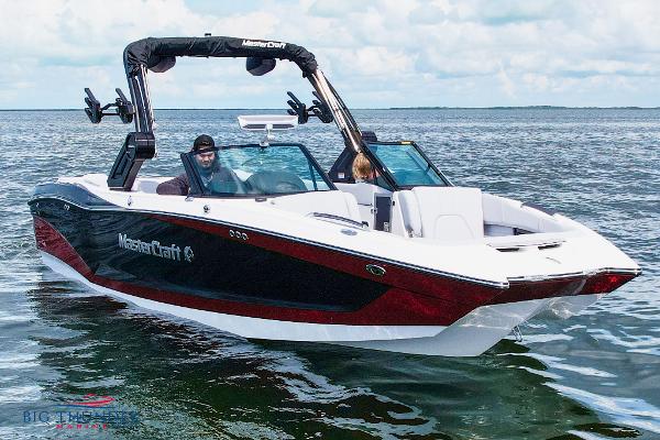 MasterCraft X24 2023 MasterCraft X24 boat cruising on open water under a clear sky.