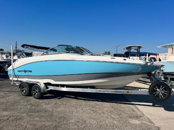 NauticStar 223DC 2024 NauticStar 223DC boat on a trailer, blue and white hull.