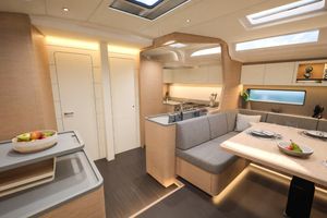 Dufour 54 Luxurious interior of 2026 Dufour 54 yacht with modern kitchen and dining area.
