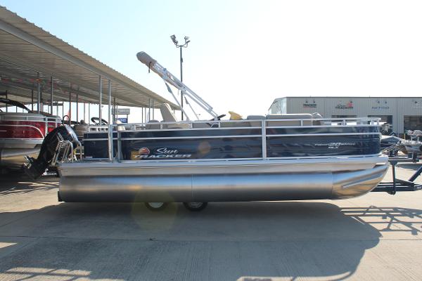 Sun Tracker Fishin' Barge 20 DLX 2025 Sun Tracker Fishin' Barge 20 DLX pontoon boat in a marina setting.