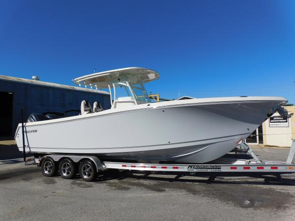Sailfish 290 CC 2023 Sailfish 290 CC boat on trailer, parked outdoors under clear blue sky.