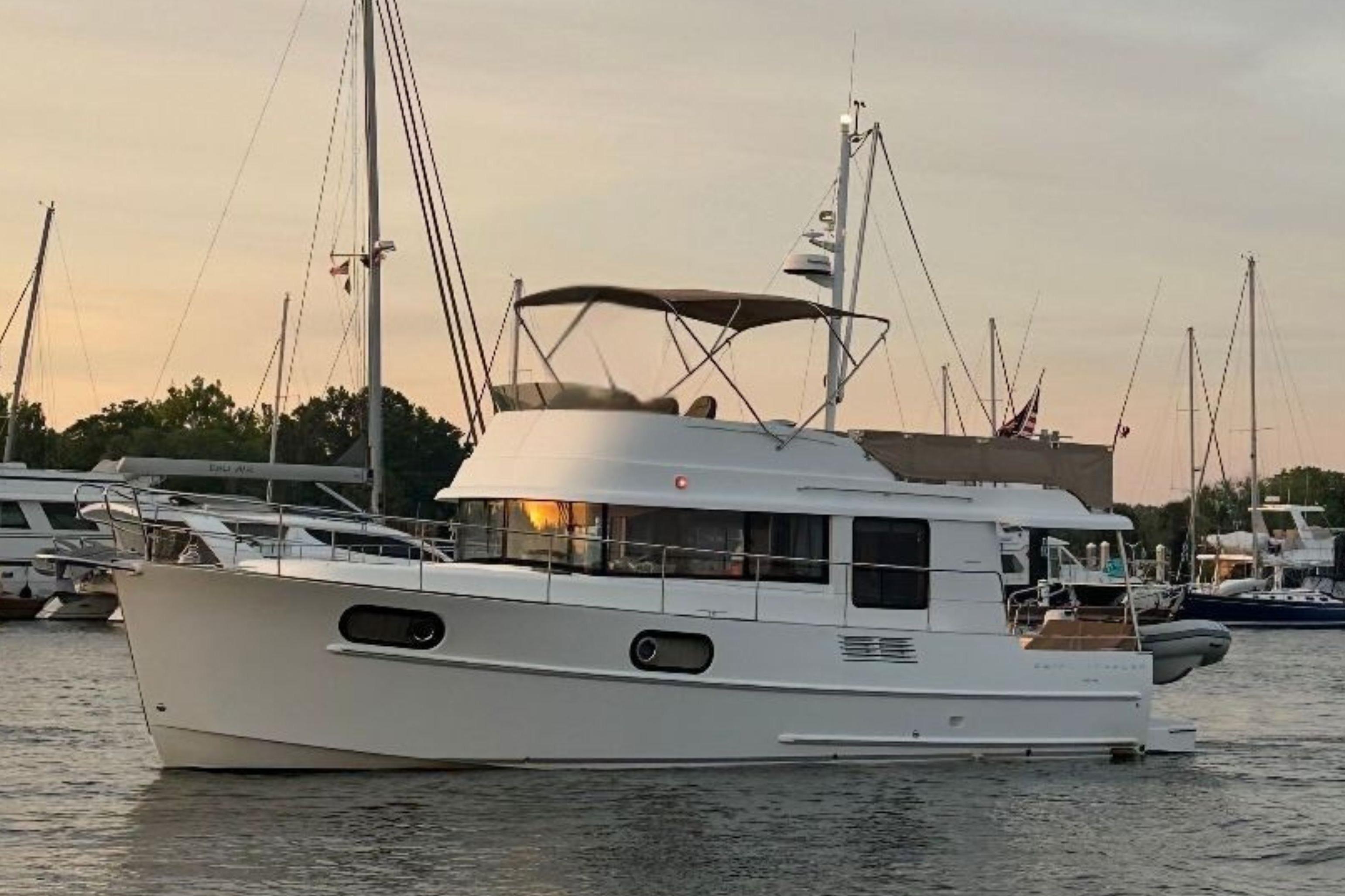 Beneteau Swift Trawler 44 2018 Beneteau Swift Trawler 44 yacht docked at sunset, surrounded by sailboats.
