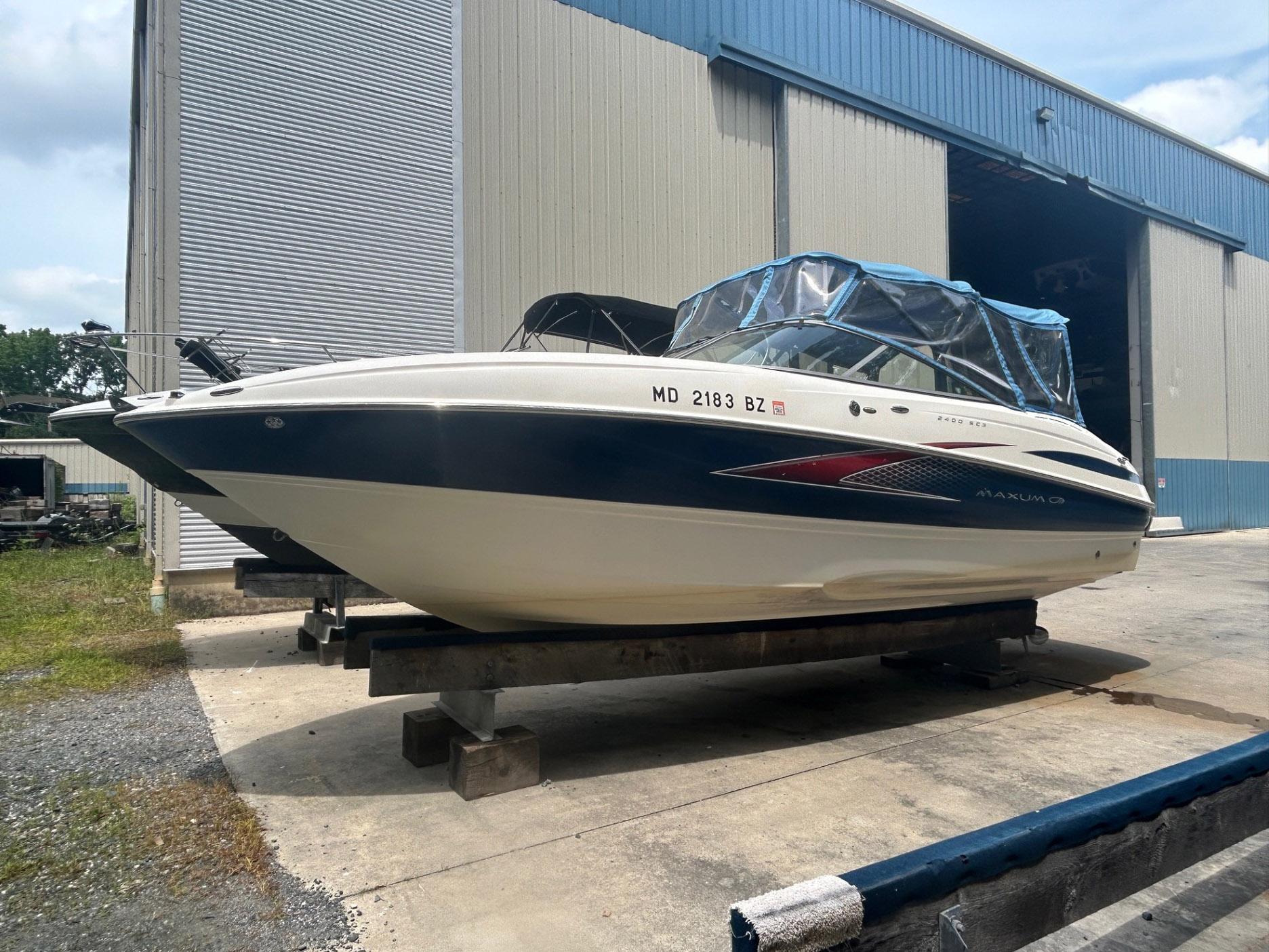Maxum 2400 SC3 2007 Maxum 2400 SC3 boat on a trailer outside a large warehouse.