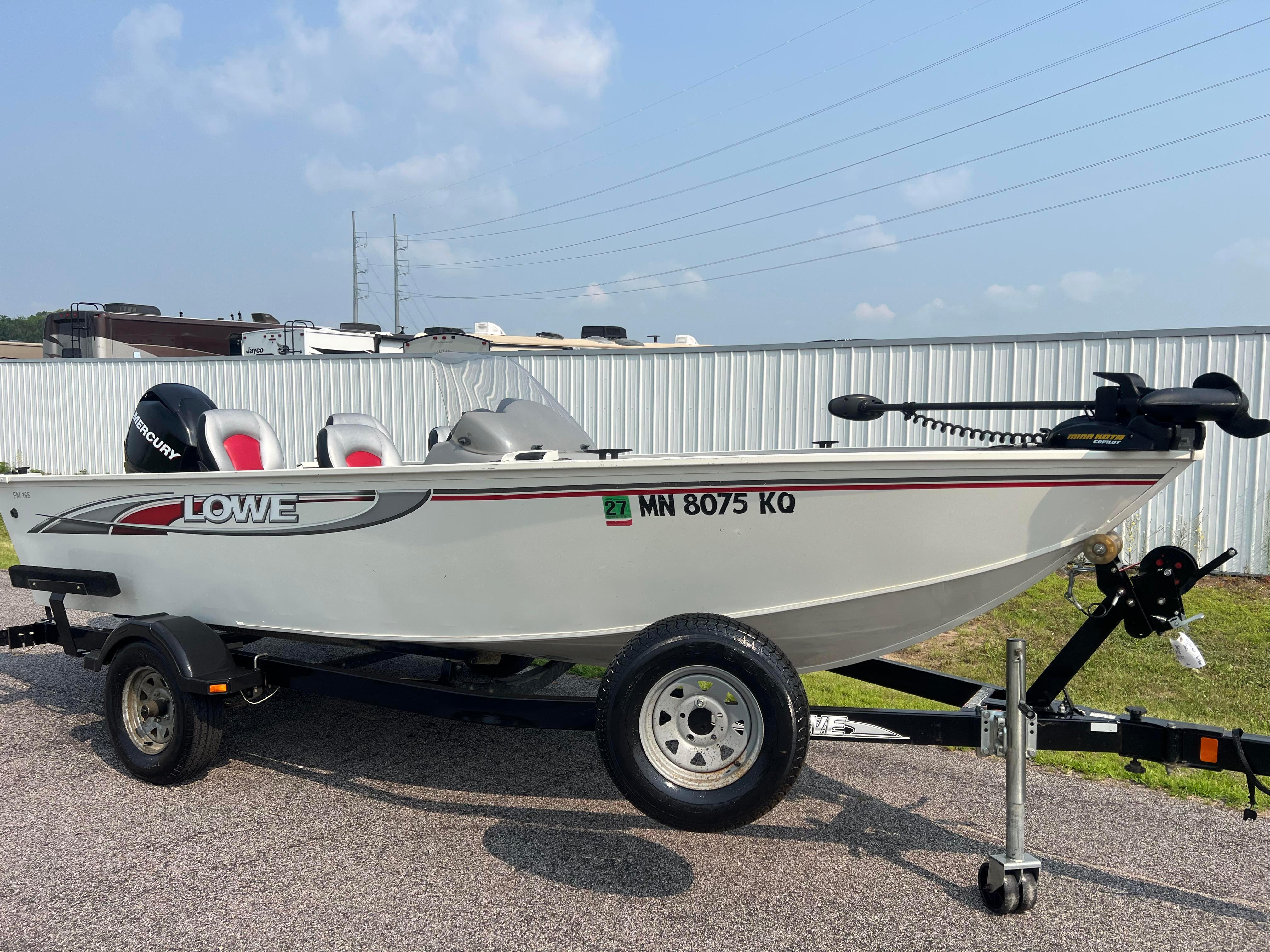 Lowe Fishing Machine 165 2010 Lowe Fishing Machine 165 boat on trailer, parked outdoors, with Mercury engine.