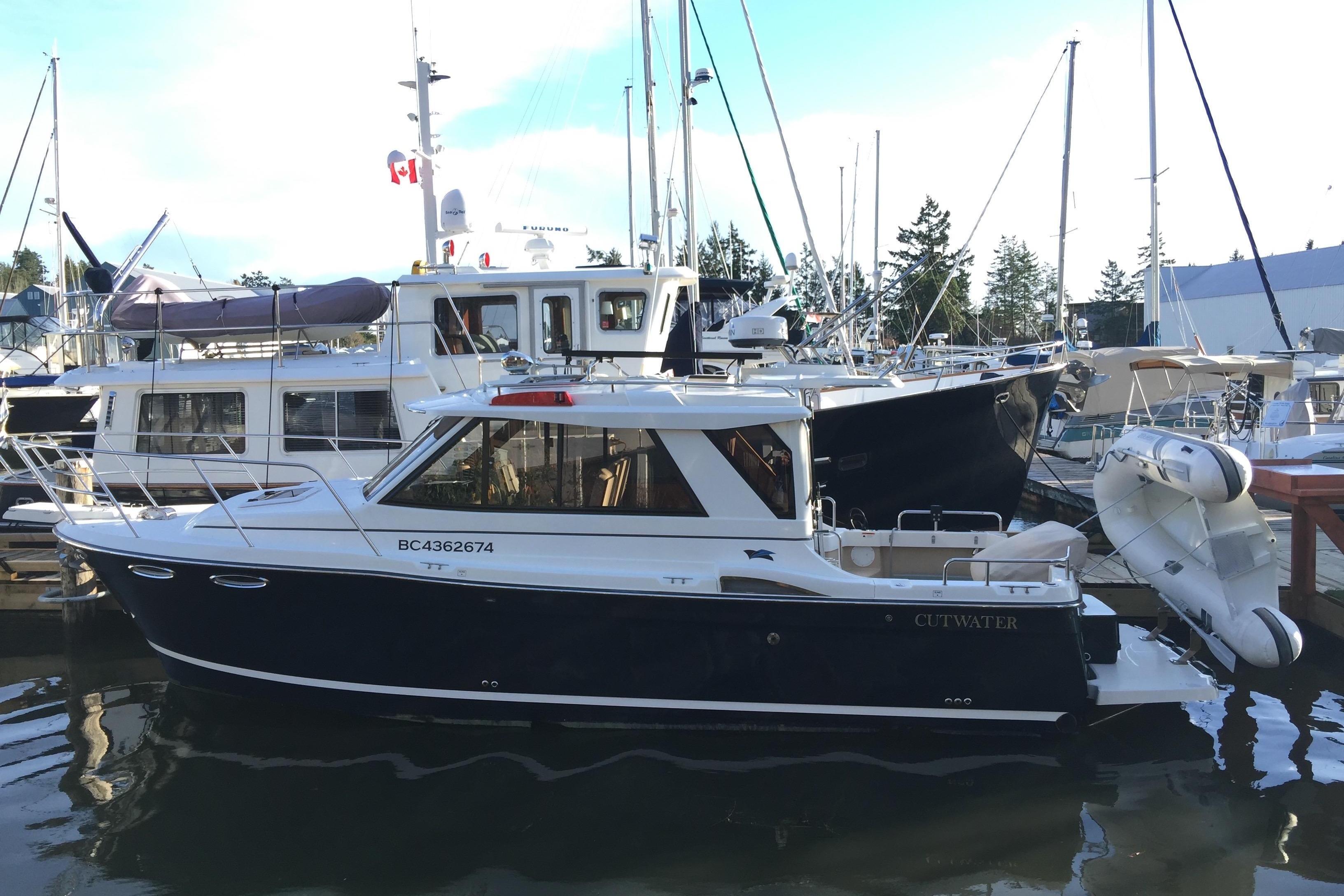 Cutwater C26 2014 Cutwater C26 boat docked at marina, surrounded by other vessels.