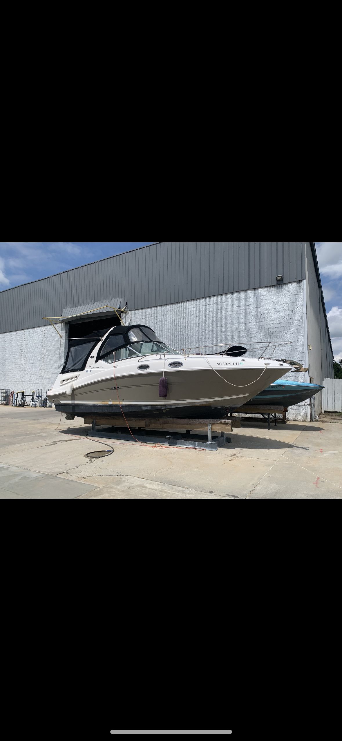 Sea Ray Sundancer 260 2006 Sea Ray Sundancer 260 boat on dry dock near industrial building.