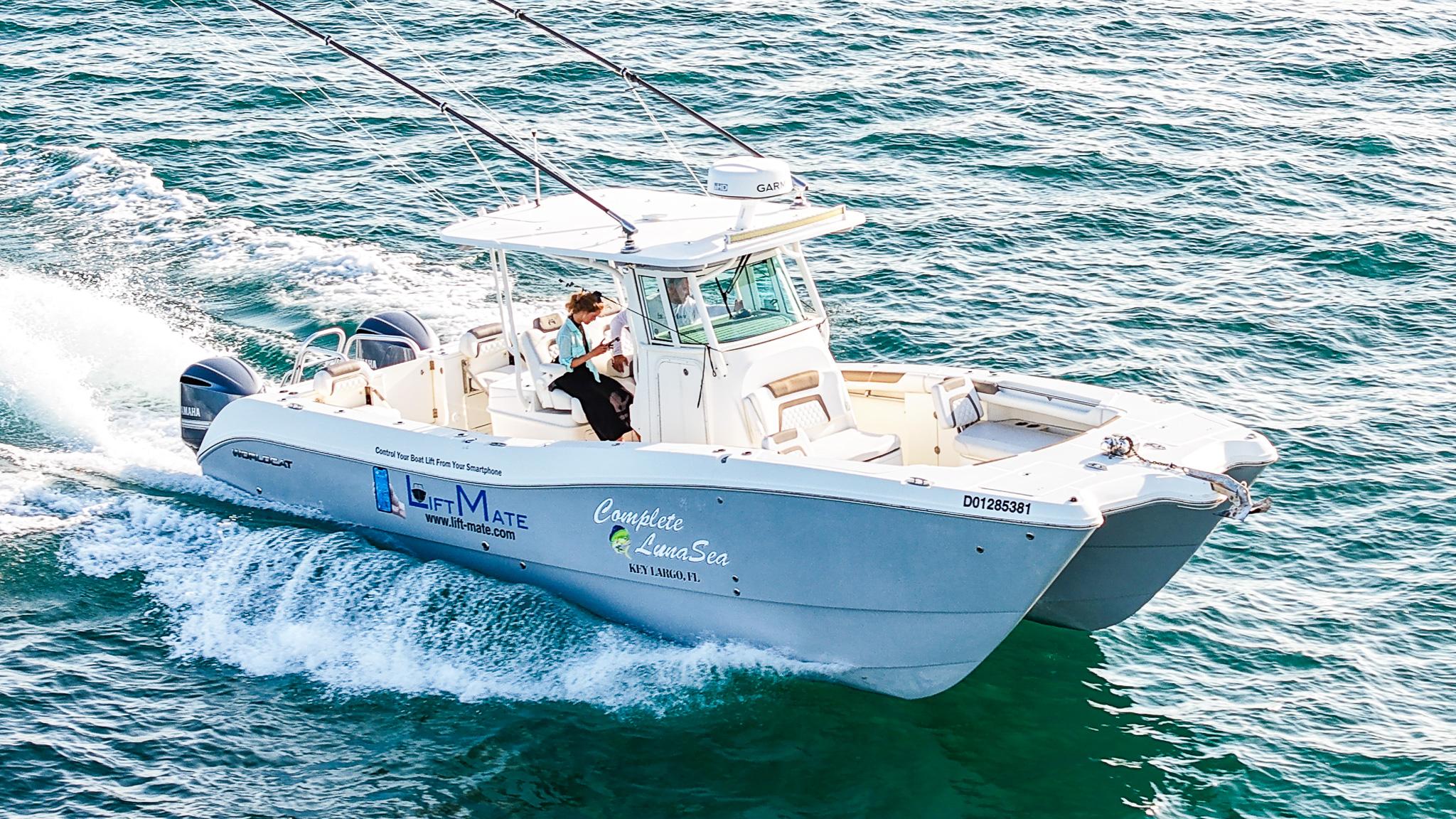 World Cat 320 CC 2018 World Cat 320 CC boat cruising on open water, featuring dual engines and fishing rods.