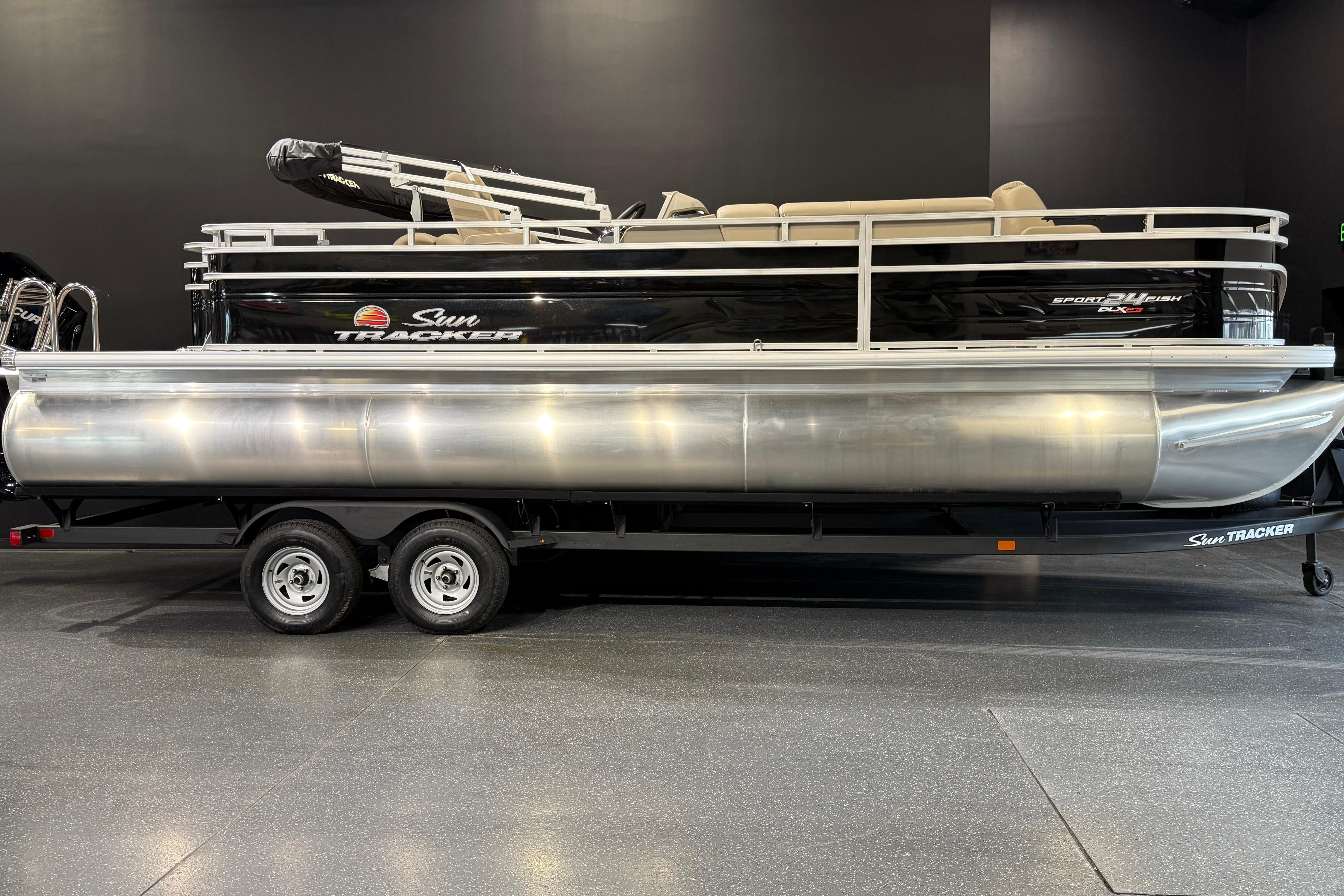 Sun Tracker Sportfish 24 XP3 2025 Sun Tracker Sportfish 24 XP3 pontoon boat on trailer in showroom.